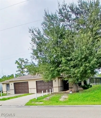 a view of a house with a tree and a yard