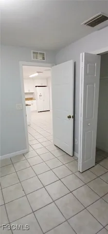 a view of a refrigerator in kitchen and empty room