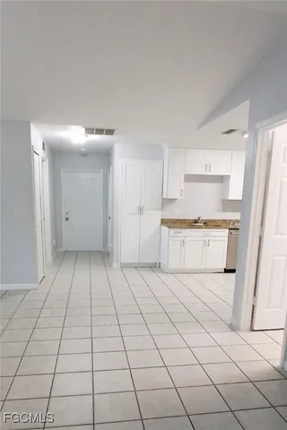 a view of a kitchen with white cabinets