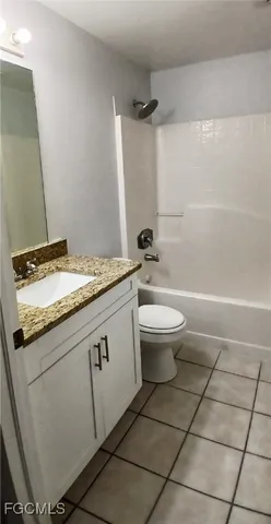 a bathroom with a granite countertop sink a toilet and a mirror