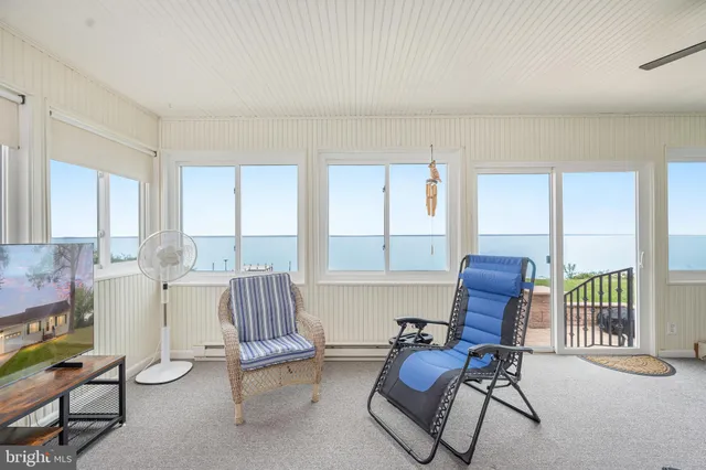 a front view of a house with garden and chairs