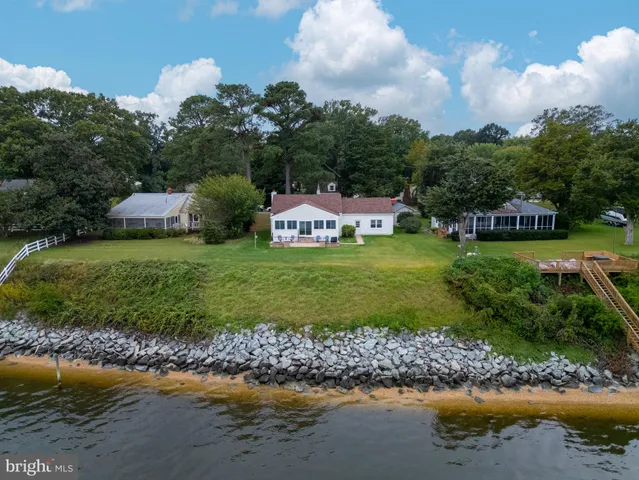 a front view of a house with a yard and outdoor seating
