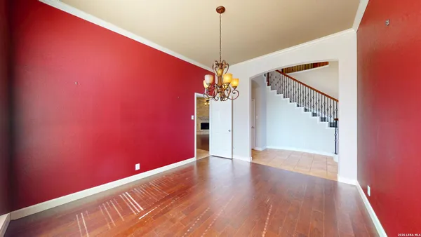 a view of a livingroom with a fireplace a ceiling fan and windows