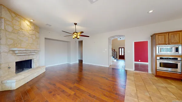 a large kitchen with stainless steel appliances a large counter top a stove and a refrigerator