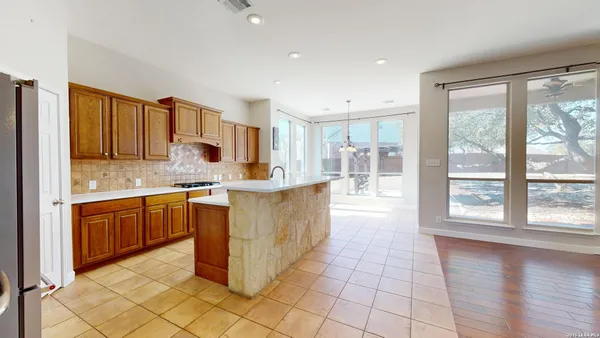 a kitchen that has a lot of cabinets and refrigerator in it