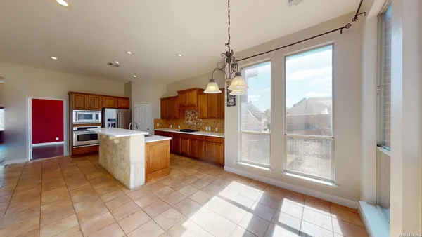 an empty room with wooden floor and a ceiling fan