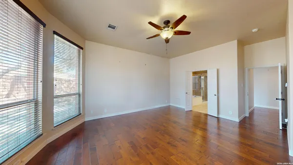 a view of an empty room with wooden floor