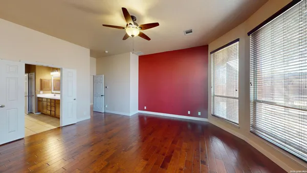 a view of an empty room with wooden floor