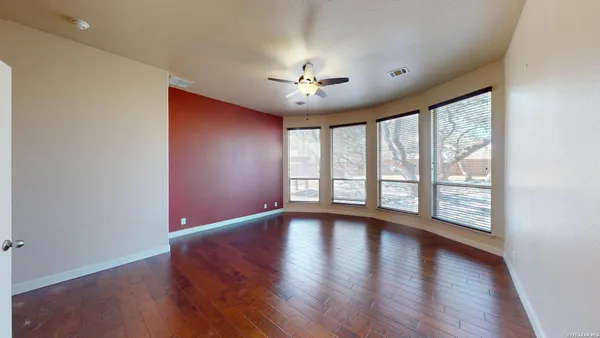 a view of empty room with wooden floor