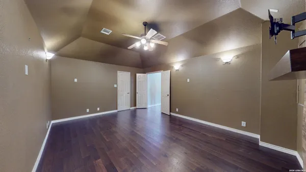 a view of an empty room with window and wooden floor