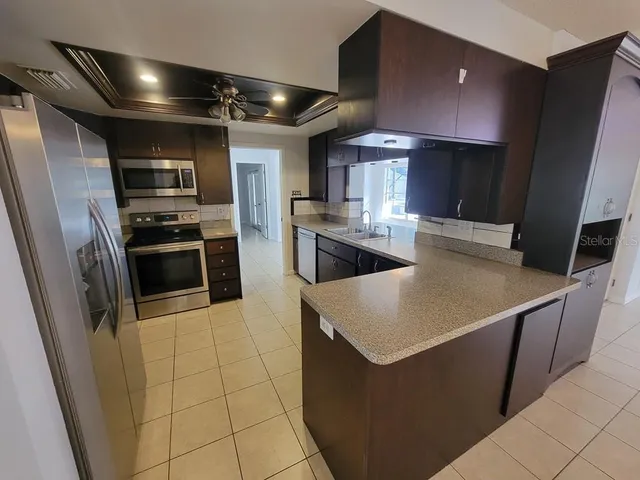 a kitchen with stainless steel appliances a stove a refrigerator and a sink