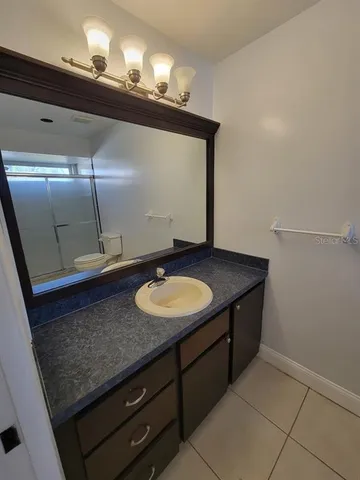 a bathroom with a granite countertop sink and a mirror