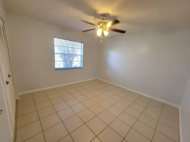 a view of an empty room with a chandelier fan