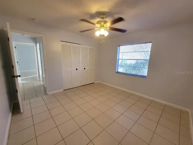 a view of an empty room with a chandelier fan