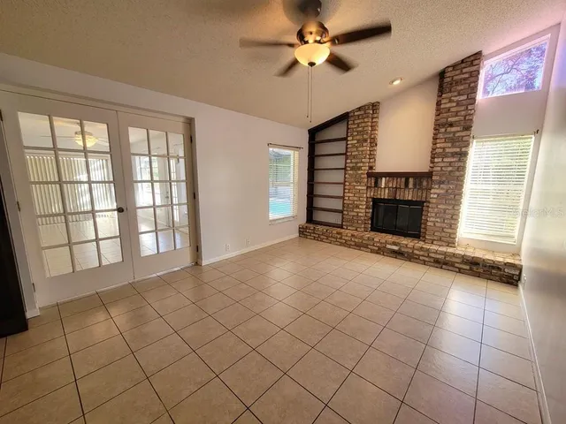 a view of an empty room with a fireplace and a window