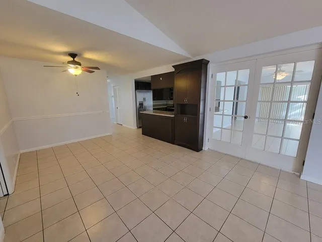 a view of a livingroom with a chandelier fan and windows