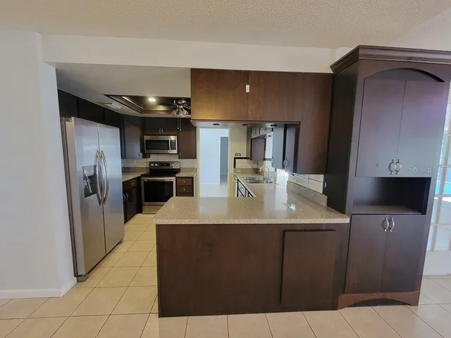 a kitchen with stainless steel appliances granite countertop a sink a stove and refrigerator