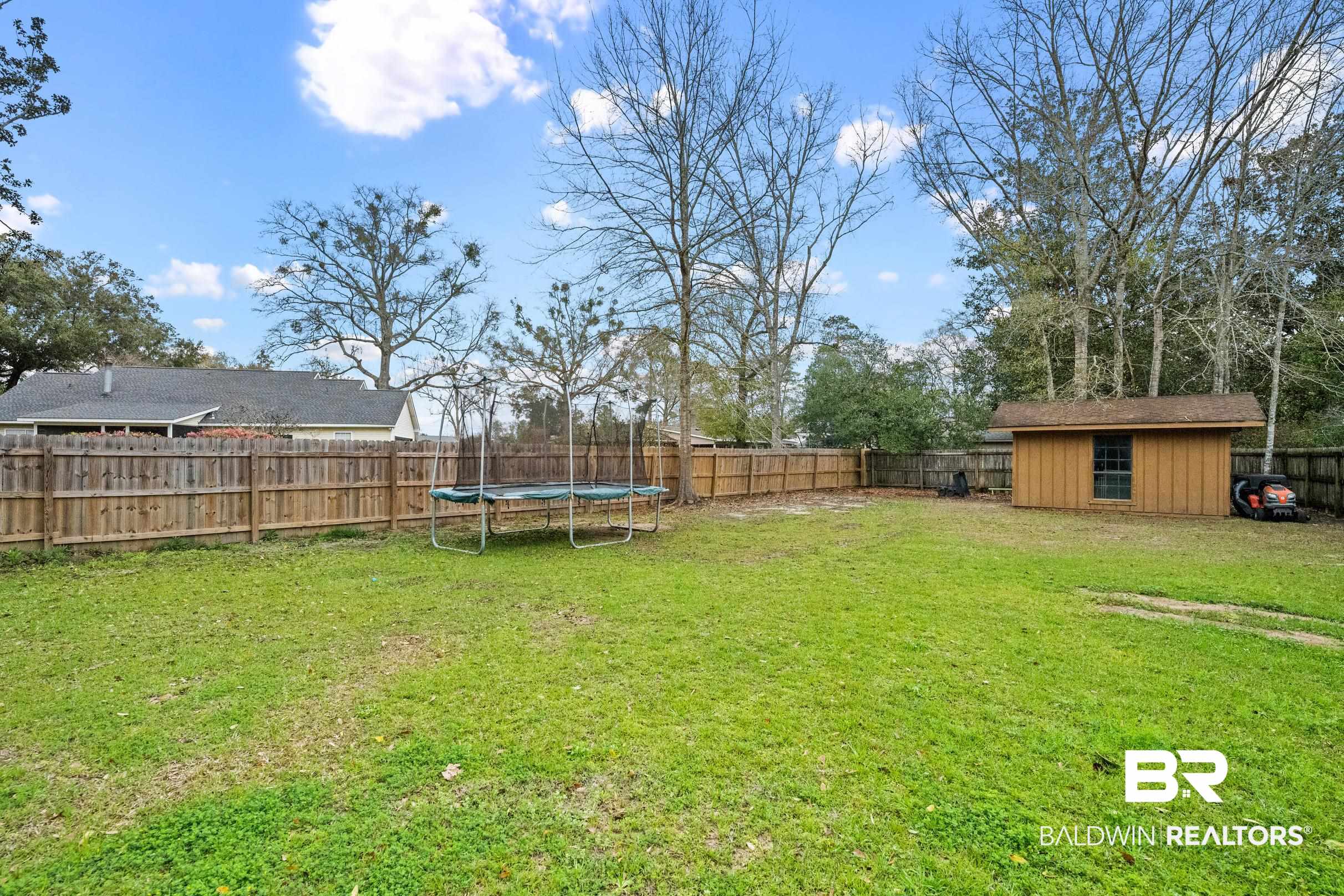6 Wren Circle Foley, AL 36535 - Photo 48 of 55 View of yard with a fenced backyard, a trampoline, an outdoor structure, and a shed