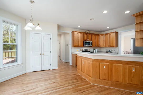 a large kitchen with granite countertop a stove a sink a center island and cabinets