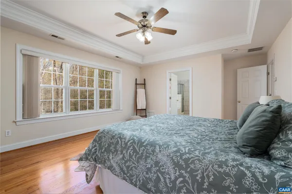 a bed sitting in a spacious bedroom next to a window