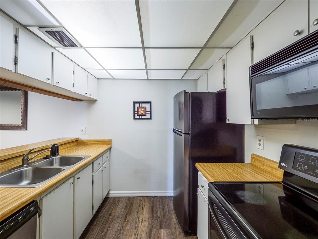 3235 South Beneva Road, Unit 101 Sarasota, FL 34232 - Photo 14 of 36 a kitchen with a refrigerator and a sink