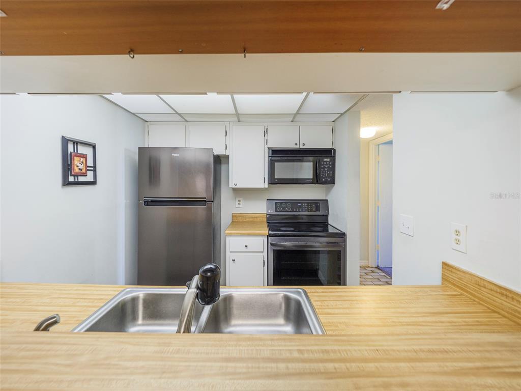 3235 South Beneva Road, Unit 101 Sarasota, FL 34232 - Photo 19 of 36 a kitchen with a refrigerator and a sink