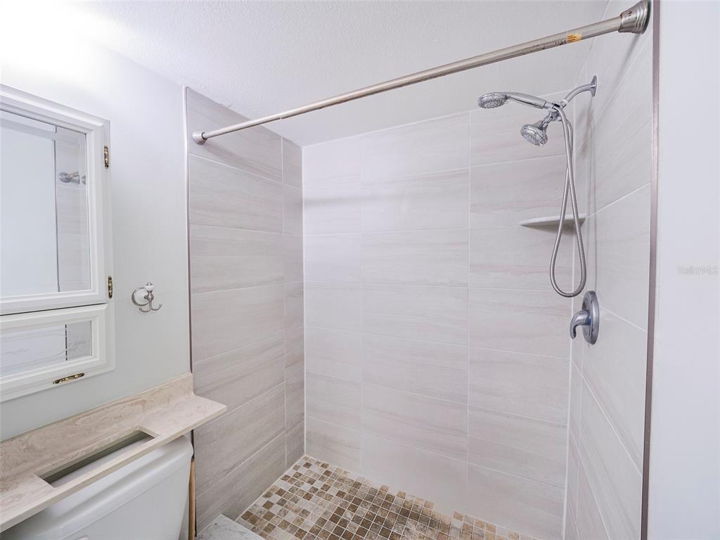 3235 South Beneva Road, Unit 101 Sarasota, FL 34232 - Photo 23 of 36 a bathroom with a sink and shower