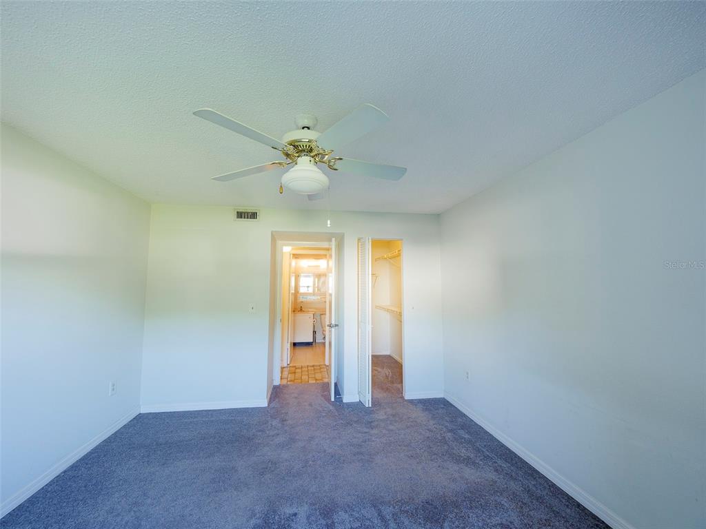3235 South Beneva Road, Unit 101 Sarasota, FL 34232 - Photo 25 of 36 an empty room with a chandelier fan and windows
