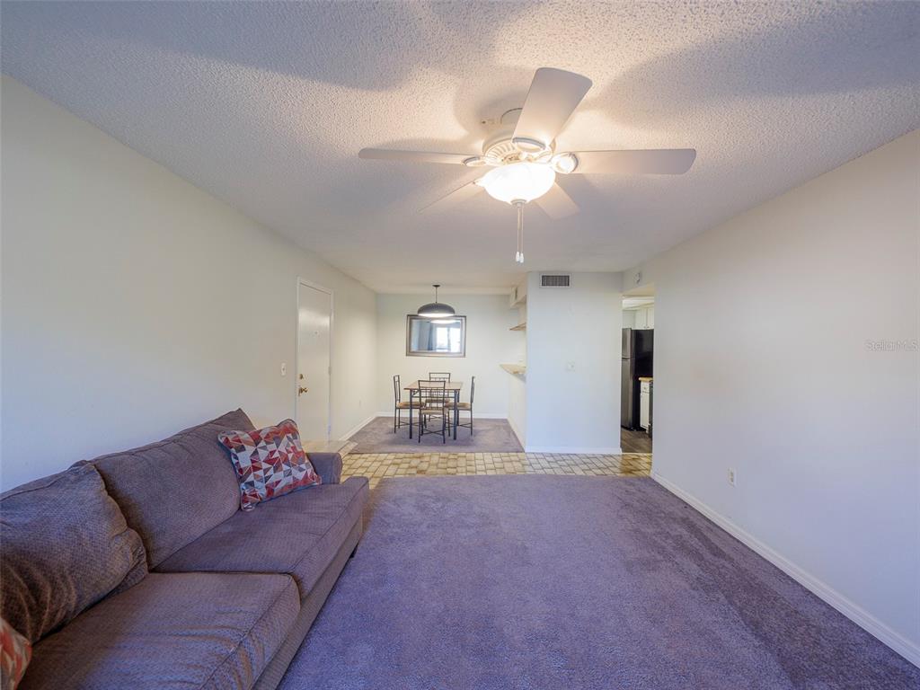 3235 South Beneva Road, Unit 101 Sarasota, FL 34232 - Photo 8 of 36 a living room with furniture and a chandelier