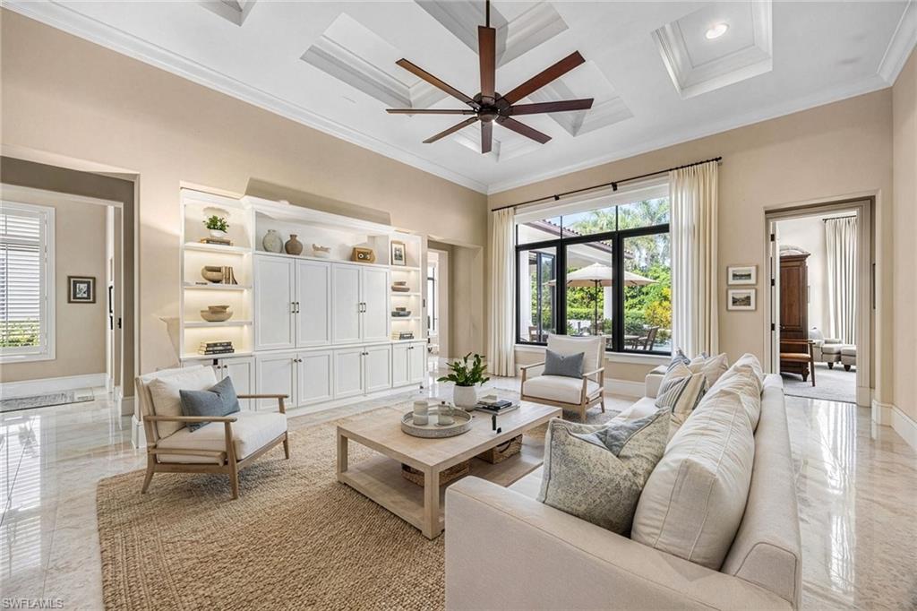2277 Residence Circle Naples, FL 34105 - Photo 12 of 41 a living room with furniture a ceiling fan and a large window