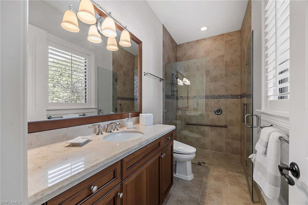 2277 Residence Circle Naples, FL 34105 - Photo 29 of 41 a spacious bathroom with a granite countertop sink a toilet a mirror and shower