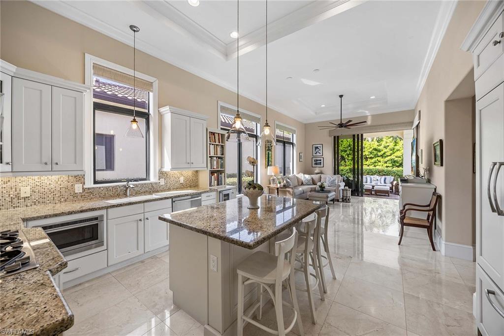 2277 Residence Circle Naples, FL 34105 - Photo 3 of 50 a kitchen with center island table and chairs in it
