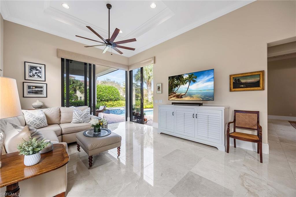 2277 Residence Circle Naples, FL 34105 - Photo 4 of 50 a living room with furniture a flat screen tv and a large window