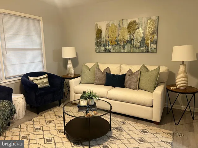 an empty room with wooden floor and fan