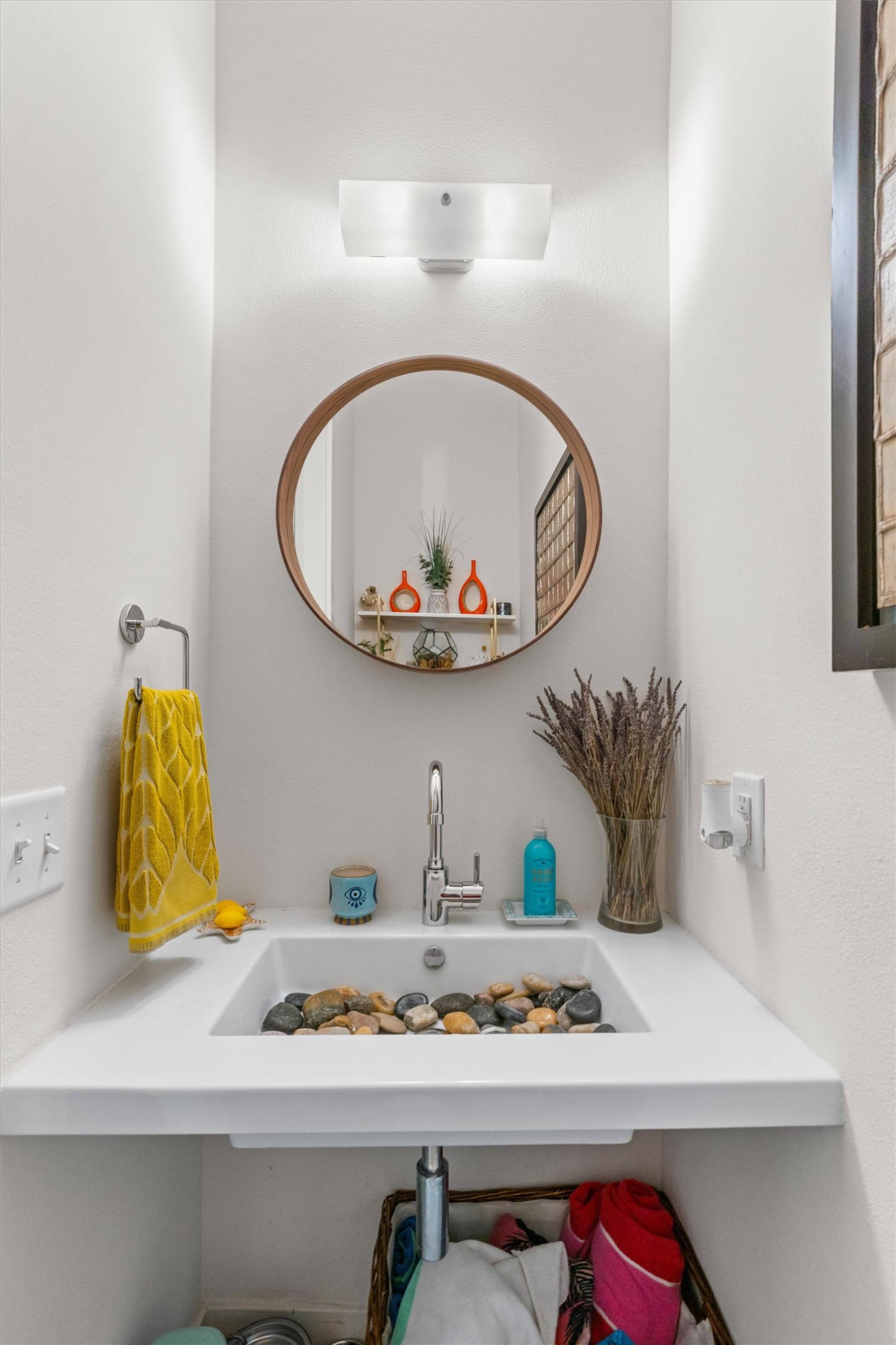 408 Starlight Village Loop Leander, TX 78641 - Photo 15 of 40 A well-appointed lavatory, featuring a sleek basin and a stylish round mirror, offers a tranquil space.
