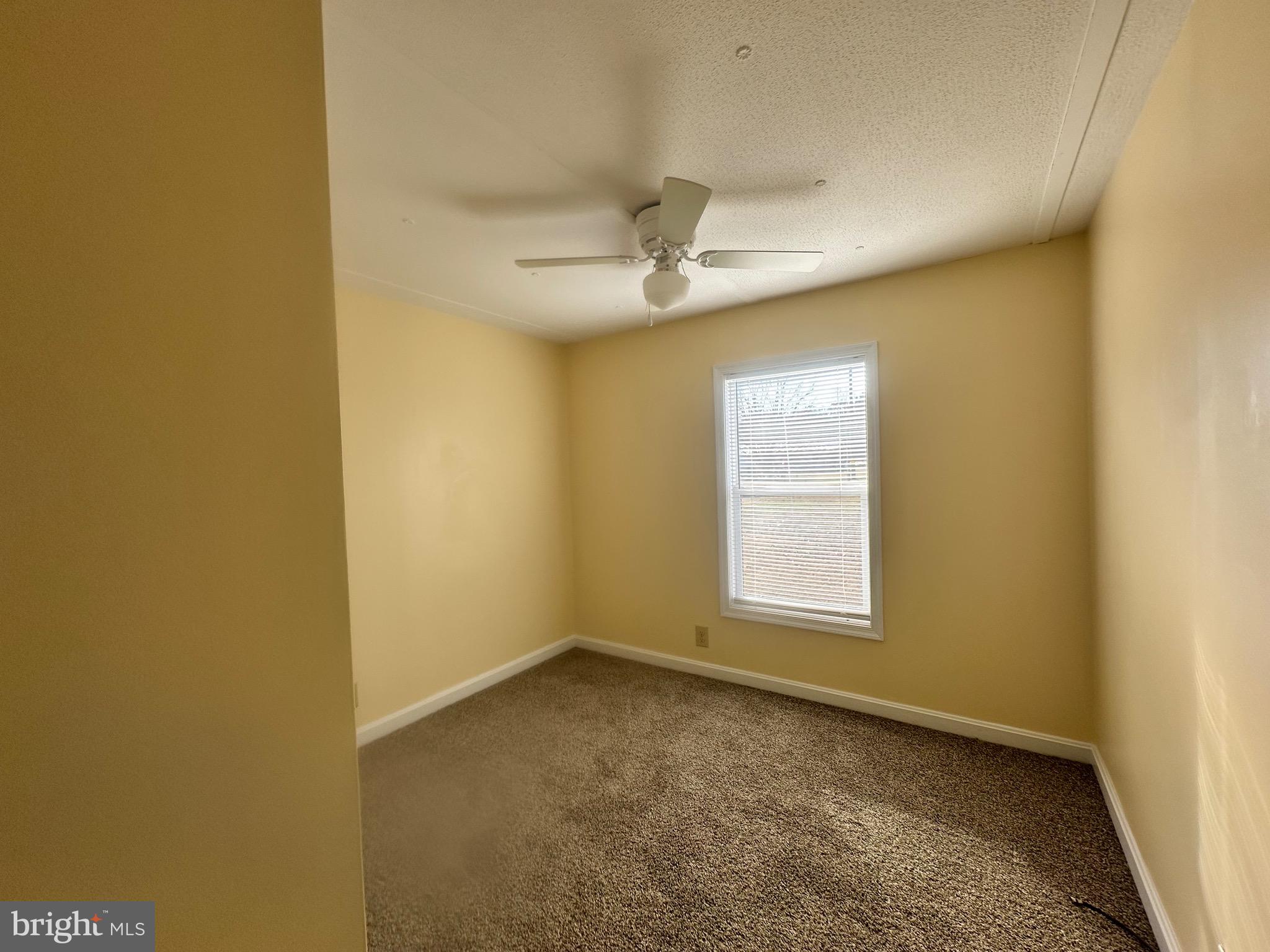 16335 Abbotts Pond Road Milford, DE 19963 - Photo 15 of 18 an empty room with a window and a ceiling fan