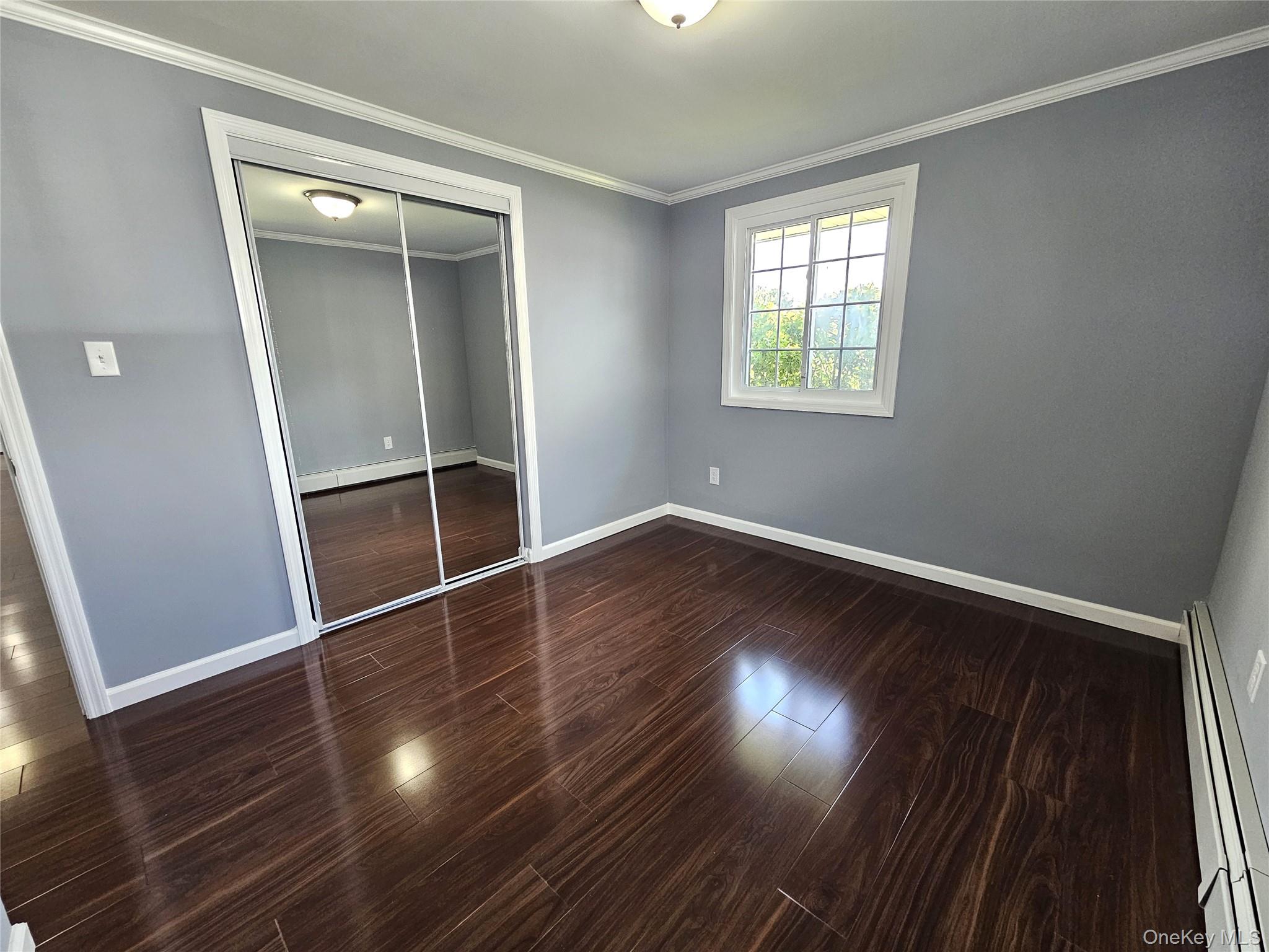 114 Granny Road Farmingville, NY 11738 - Photo 12 of 22 an empty room with wooden floor and windows