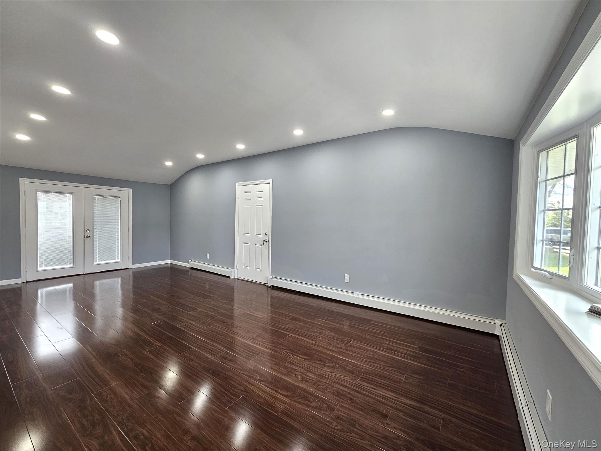 114 Granny Road Farmingville, NY 11738 - Photo 2 of 22 a view of an empty room with wooden floor and a window