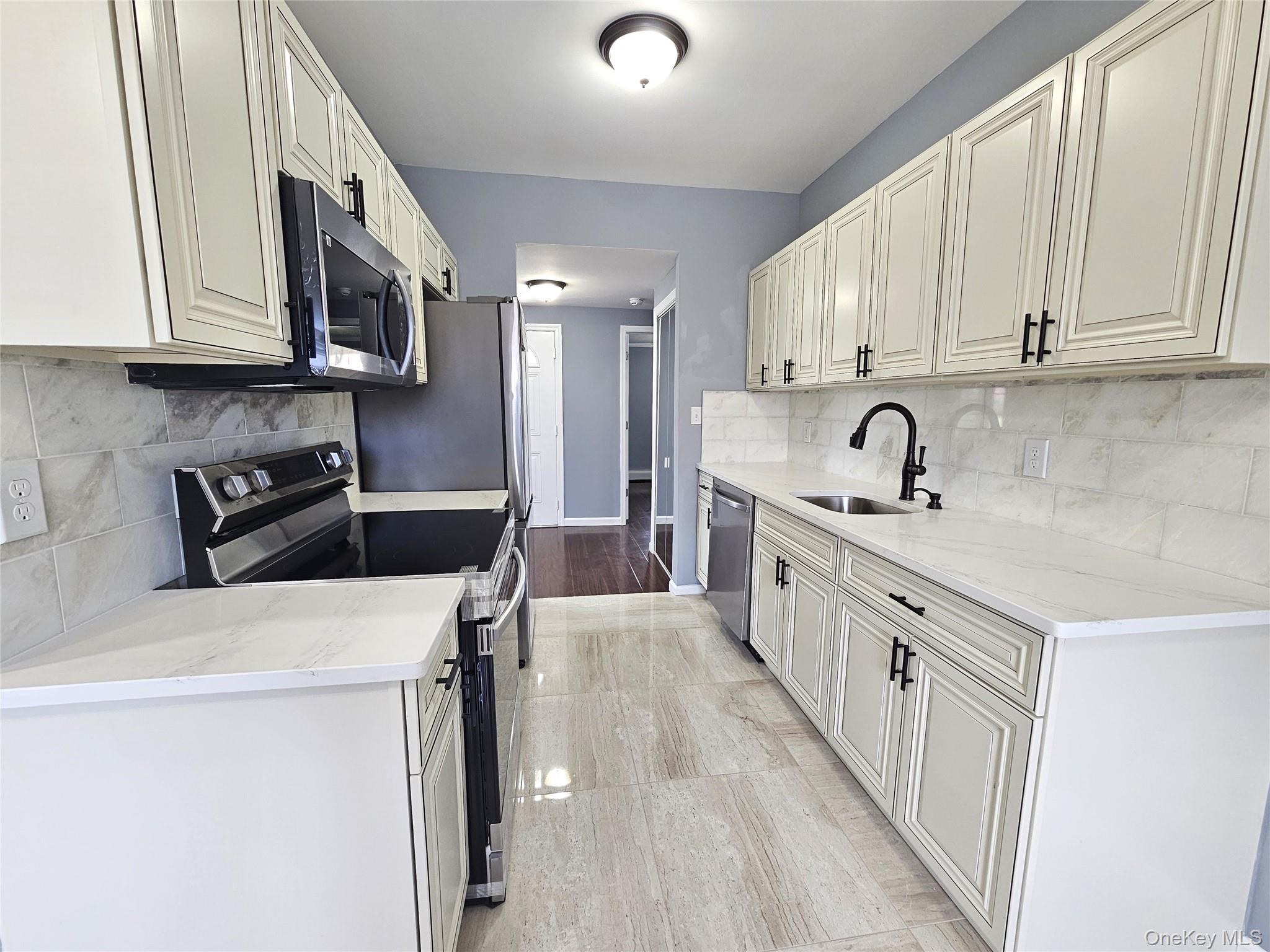 114 Granny Road Farmingville, NY 11738 - Photo 7 of 22 a kitchen with a sink a stove and cabinets