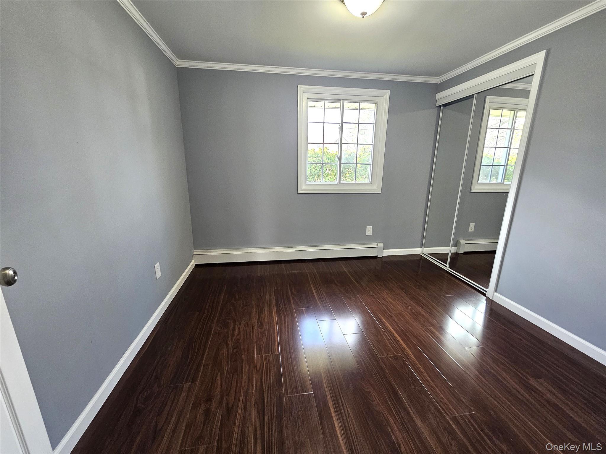 114 Granny Road Farmingville, NY 11738 - Photo 10 of 22 an empty room with wooden floor and windows
