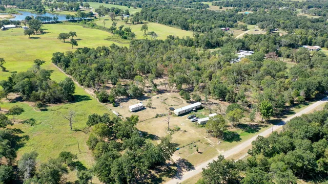 an aerial view of residential houses with outdoor space and trees