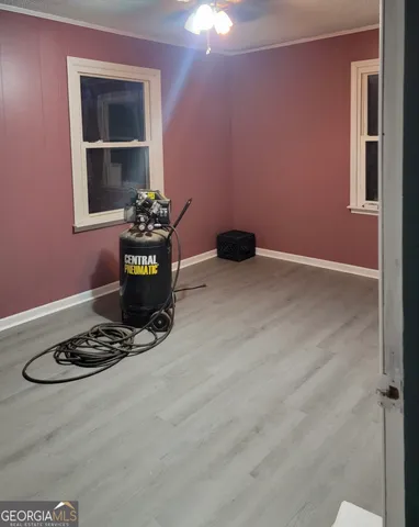 a view of a livingroom with wooden floor and a refrigerator