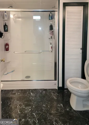 a bathroom with a toilet and a shower