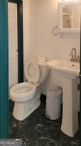 a white toilet sitting next to a bathroom sink