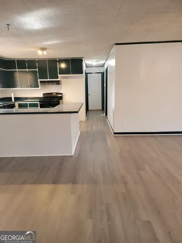 a view of kitchen with stainless steel appliances granite countertop cabinets and a wooden floor
