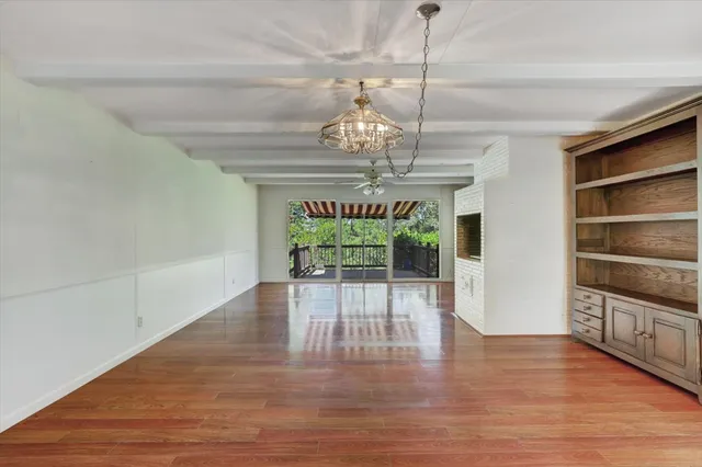a view of a room with wooden floor chandelier and entryway