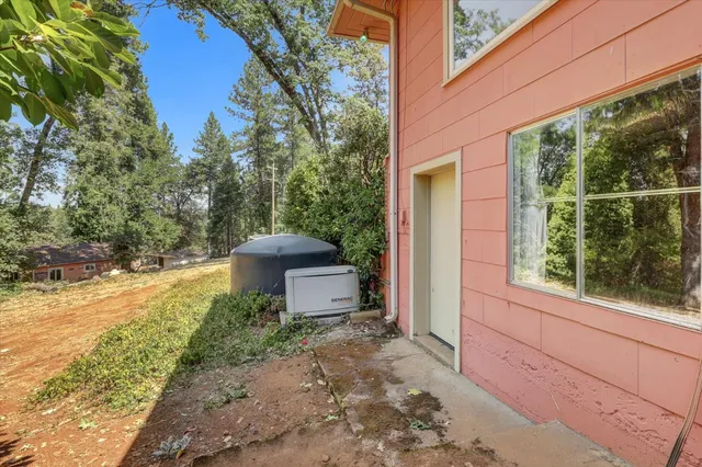 a view of a house with a lush green forest