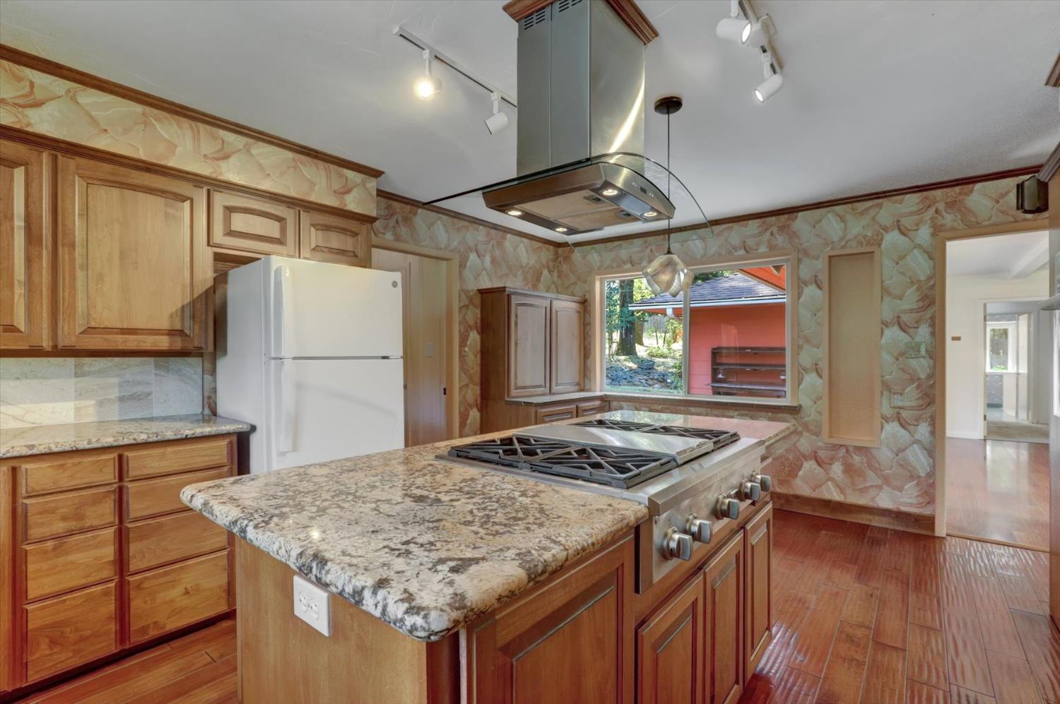 10124 South Ponderosa Way Rough and Ready, CA 95975 - Photo 5 of 63 a kitchen with a stove a refrigerator and wooden cabinets