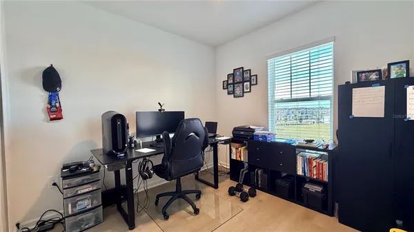 a view of a workspace with furniture and a window