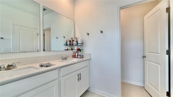 a bathroom with a double vanity sink mirror and shower